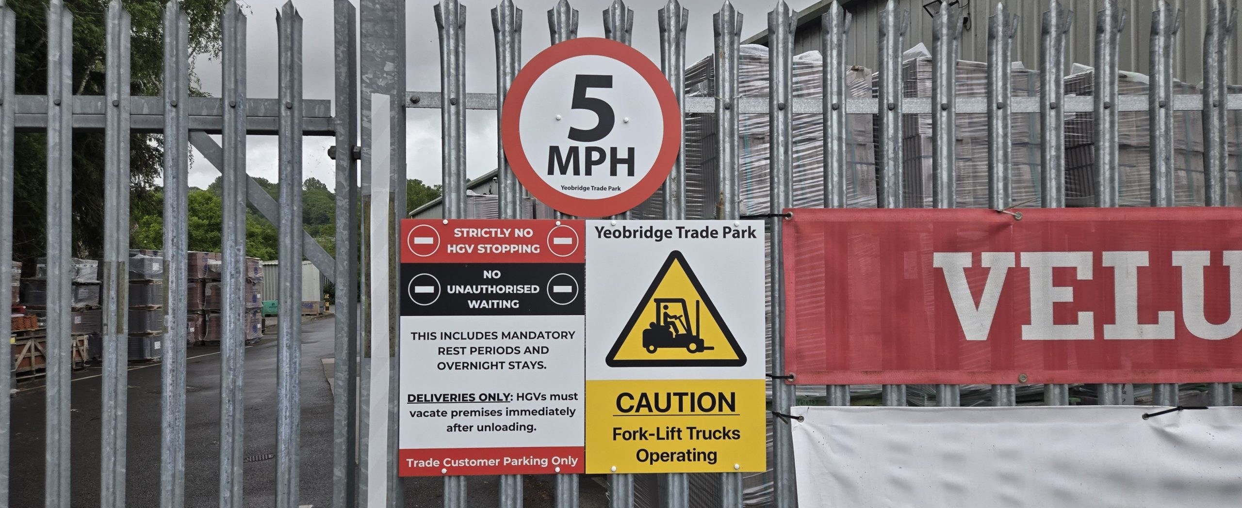 5mph speed limit, HGV waiting restriction and forklift warning signage mounted on the site entrance gate