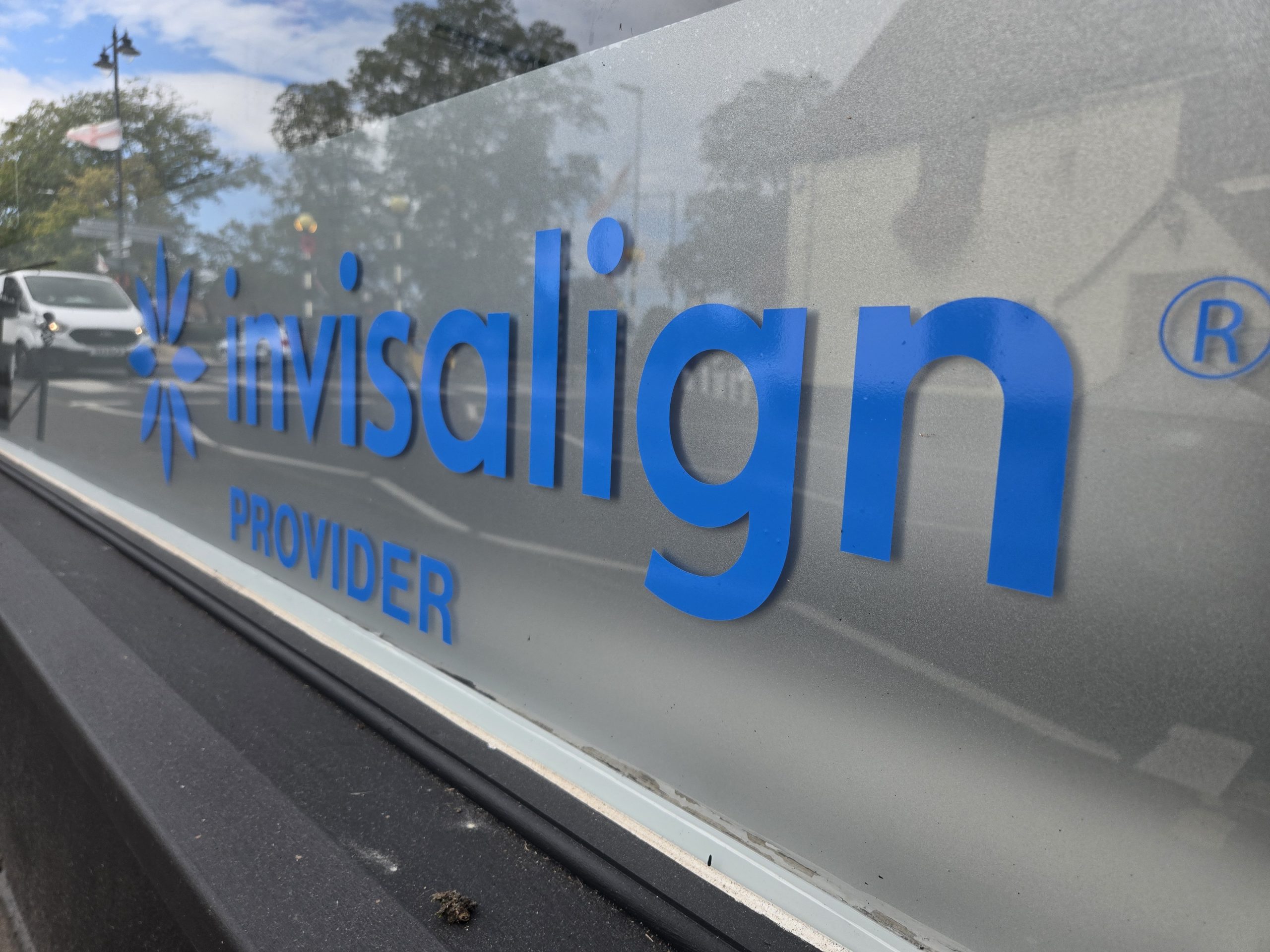 Blue Invisalign provider decal applied over frosted film on the Niceteeth window.