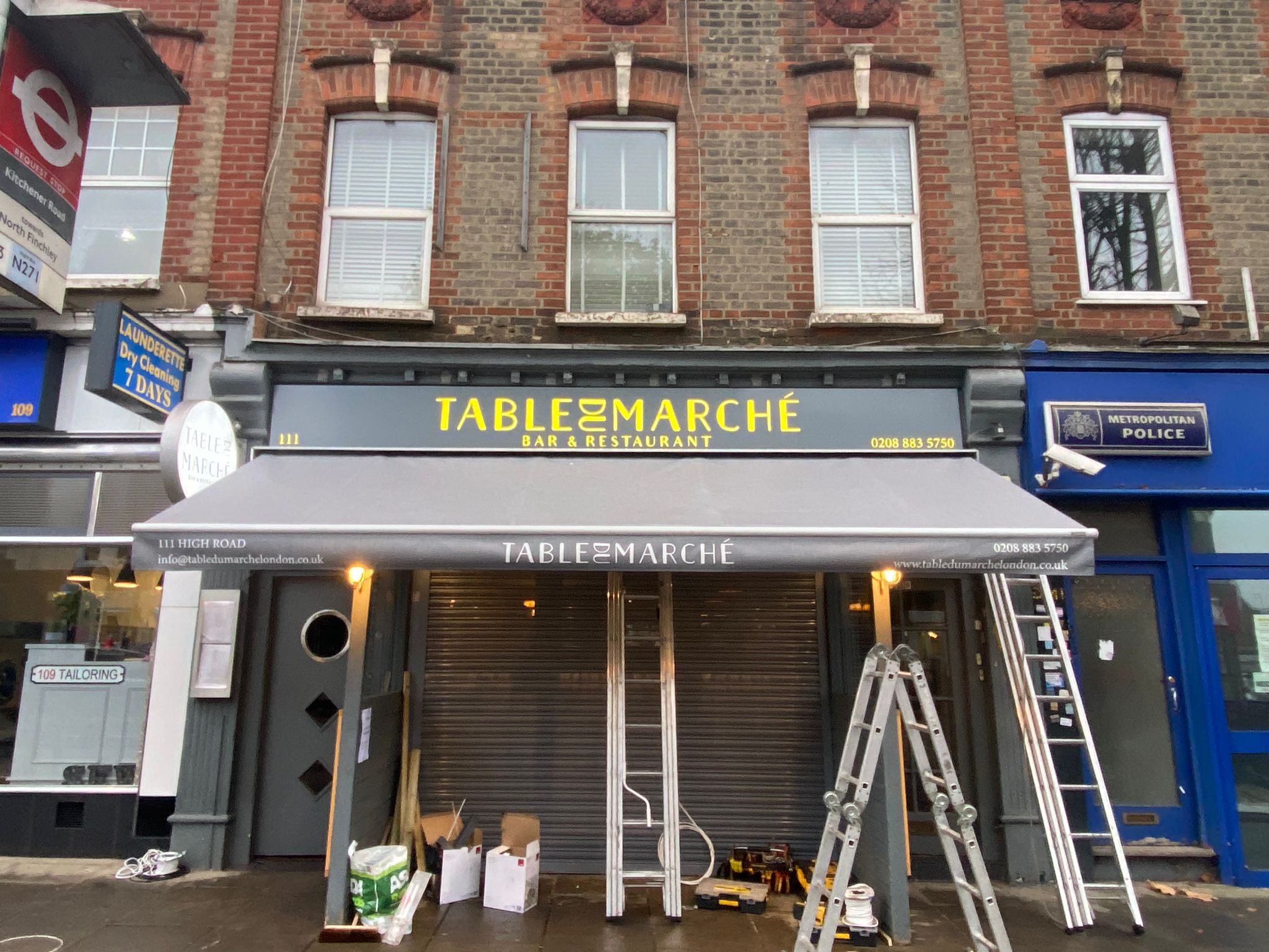 Gold Table du Marché lettering set against the grey fascia above the restaurant awning.