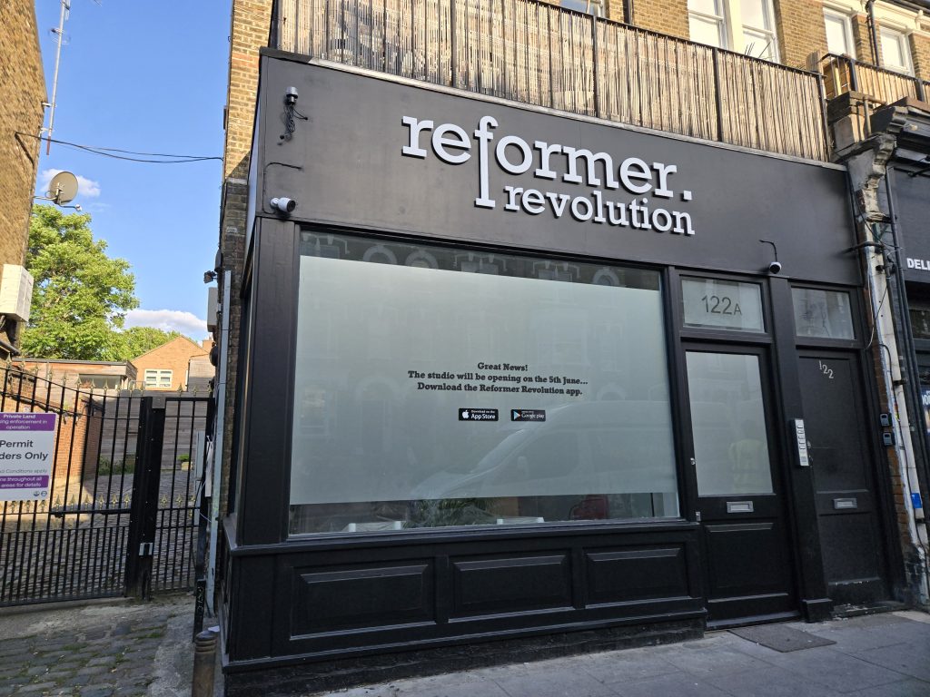 Reformer Revolution shopfront window graphics announcing the studio opening date and app download ahead of launch