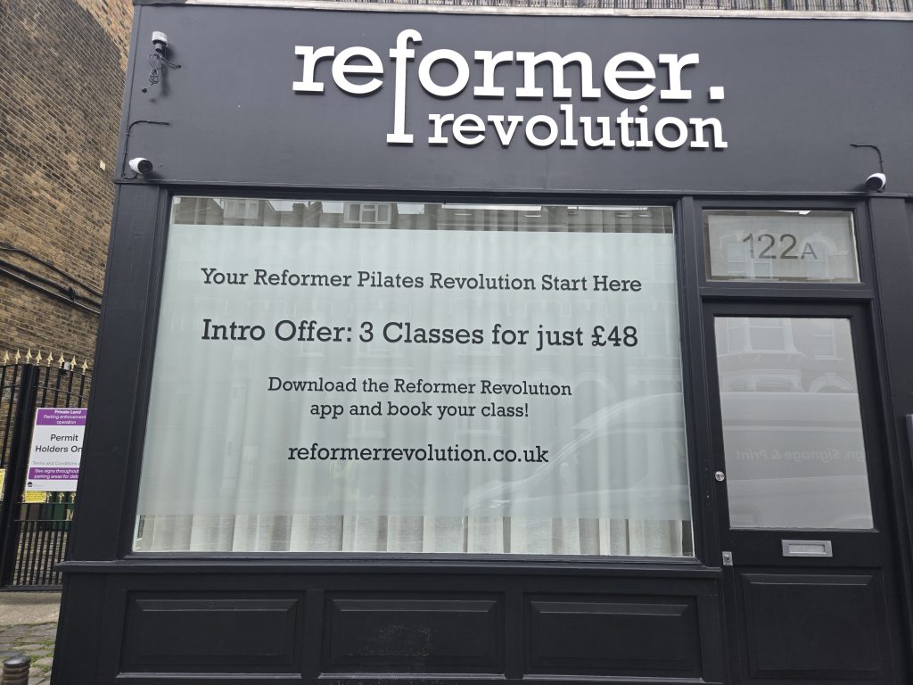 Reformer Revolution Pilates studio shopfront in Tufnell Park with acrylic fascia lettering, frosted window graphics and Intro Offer messaging