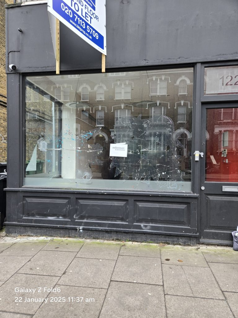 Empty Reformer Revolution premises in Tufnell Park before fit-out, with bare glazing and a handwritten opening sign