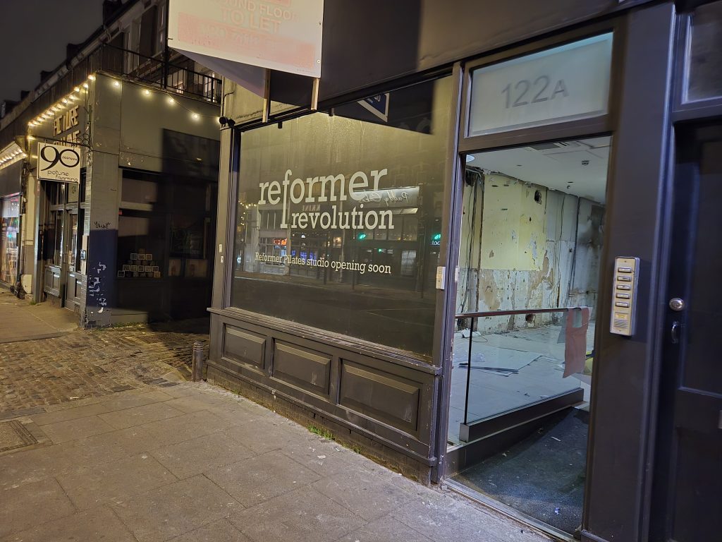 Reformer Revolution pre-launch window graphics on the Tufnell Park shopfront with the unfinished interior visible through the open door